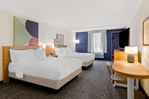 a hotel room with two beds and a desk at Spark by Hilton Daleville Roanoke North in Daleville