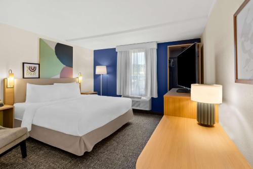 a hotel room with a bed and a tv at Spark by Hilton Daleville Roanoke North in Daleville