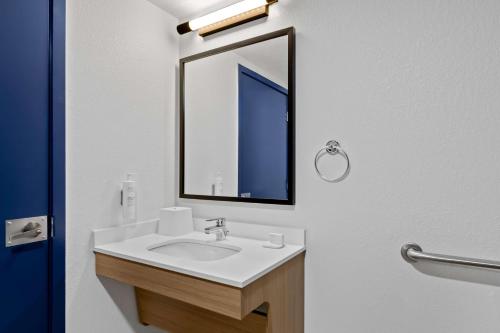 a bathroom with a sink and a mirror at Spark by Hilton Daleville Roanoke North in Daleville