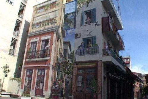 a tall building with people on the balconies of it at Loft bianco nero in Tríkala