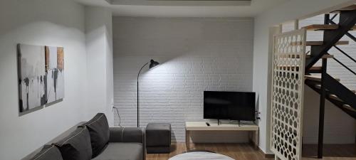 a living room with a couch and a television at Loft bianco nero in Tríkala