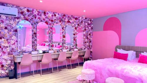 a pink room with a bed and a vanity with pink chairs at Yellow Bee Resort Cililitan in Jakarta