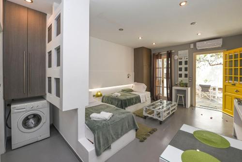 two beds in a room with a washing machine at Alento Apartments in Tinos Town