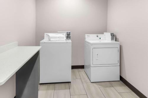 a laundry room with a washer and a dryer at Clarion Pointe - Fort Worth Arlington West in Fort Worth