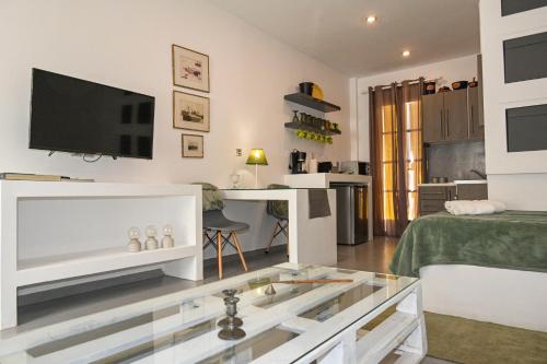 a living room with a tv and a table at Alento Apartments in Tinos Town