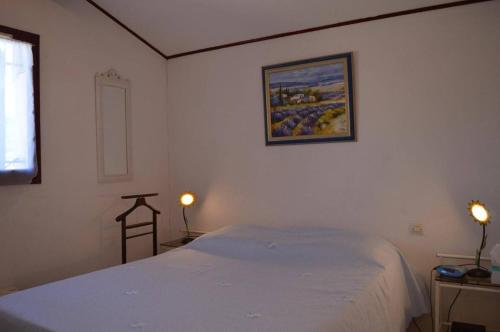 - une chambre avec un lit blanc et une photo sur le mur dans l'établissement Maison 3 pièces 6 couchages SAINT CYPRIEN SC040-014, à Saint Cyprien Plage