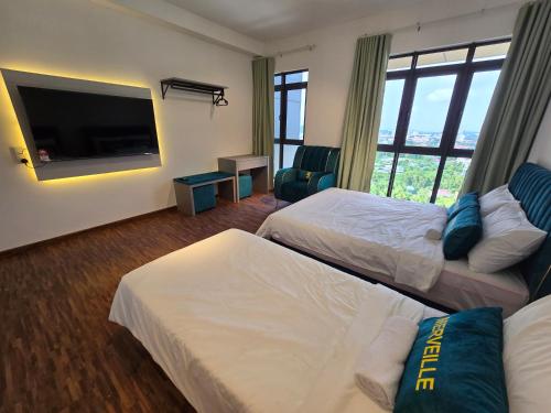 a hotel room with two beds and a flat screen tv at K Avenue Kota Kinabalu by Merveille - Sabah in Donggongon