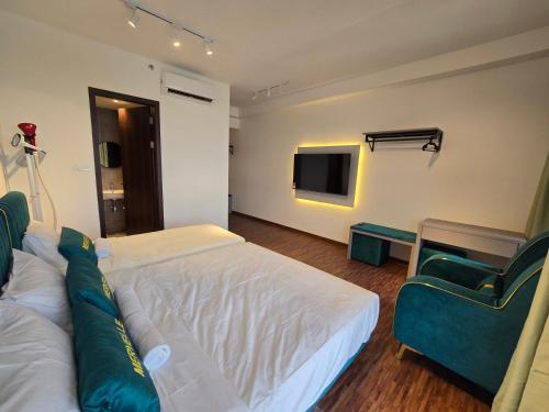 a bedroom with a bed and a couch and a tv at K Avenue Kota Kinabalu by Merveille - Sabah in Donggongon