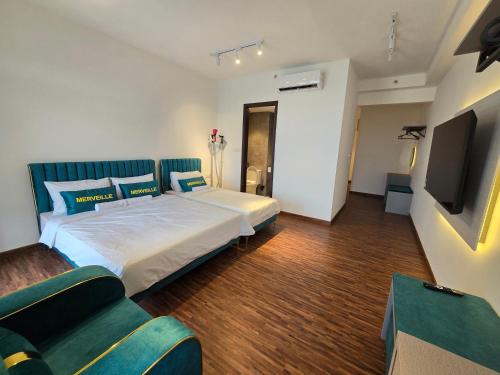 a bedroom with a large bed and a tv at K Avenue Kota Kinabalu by Merveille - Sabah in Donggongon