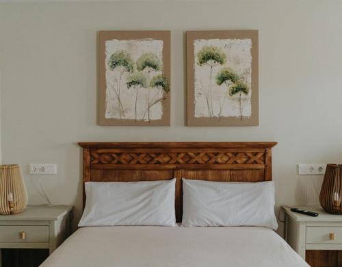 a bedroom with a bed with two pictures on the wall at Casa Rural La Medica in Sargentes de la Lora