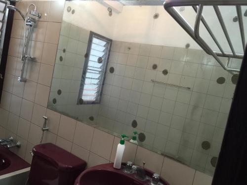a bathroom with a toilet and a mirror at 42 Guest House in Bangkok