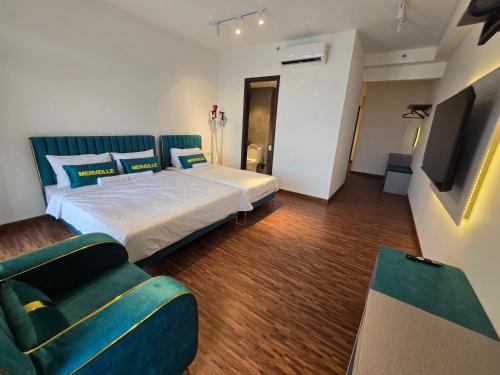 a bedroom with a bed and a tv and a couch at K Avenue Kota Kinabalu by Merveille - Sabah in Donggongon