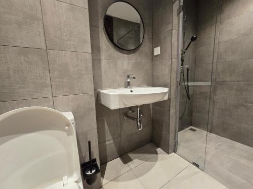 a bathroom with a sink and a toilet and a mirror at K Avenue Kota Kinabalu by Merveille - Sabah in Donggongon