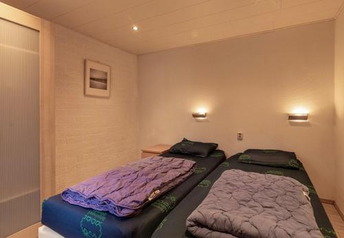 2 Betten in einem kleinen Zimmer in der Unterkunft Bungalowpark Simpelveld - Schakel 6 in Simpelveld