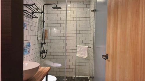 a bathroom with a sink and a glass shower at Chill Roof Hotel in Taipei