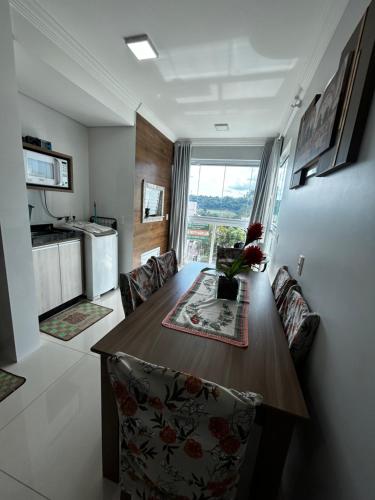 a kitchen and dining room with a wooden table and chairs at APARTAMENTO BRISA do SOL 202 in Piratuba