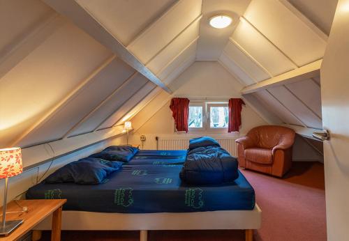 a room with a bed and a chair in a attic at Bungalowpark Simpelveld - Delta 118 in Simpelveld