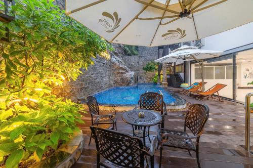 a patio with a table and chairs and a swimming pool at Green LP Hotel & Apartment in Vung Tau