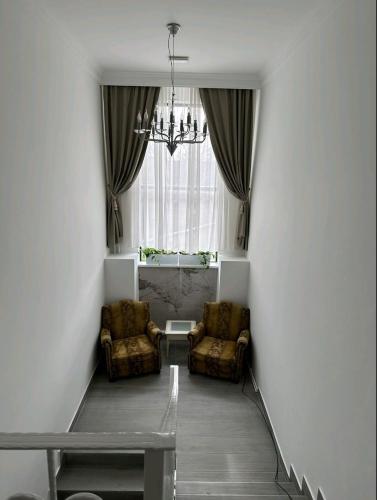 a hallway with two chairs and a table and a window at Apartmani, New Museum Kula in Kula