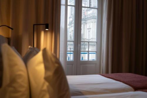 a bedroom with a bed and a large window at Templo Hotel & SPA in Braga