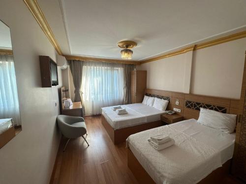 a hotel room with two beds and a chair at Delbab PANSİYON in Istanbul