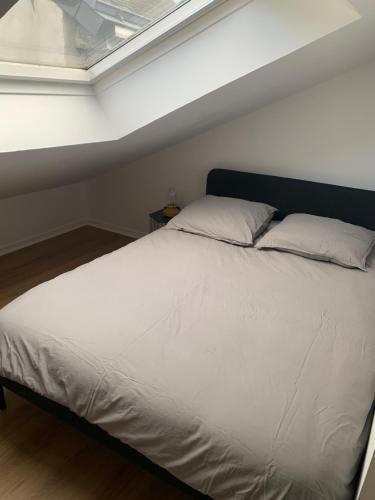 une chambre avec un grand lit blanc avec une fenêtre dans l'établissement Appartement coeur de ville - 4 couchages, à Nantes