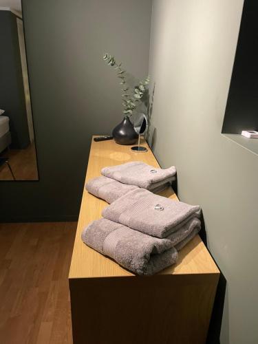 three towels are stacked on a table in a bathroom at Modern Apartment with Aurora & Midnight Sun Views, Close to Snow Dome, ski slopes Store & Bus Stop, Free Parking in Tromsø