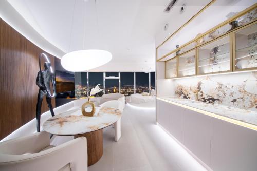 a room with white furniture and a table and chairs at Sky Tower - 48 Piętro Penthousy z Prywatna SPA - ADULT ONLY in Wrocław