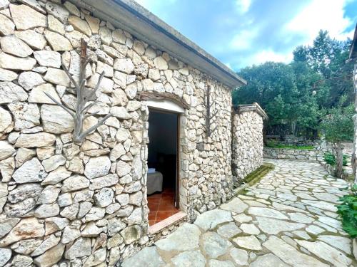 an entrance to a stone building with a door at Su Barraccu Del Golgo in Baunei