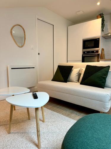 a living room with a couch and a table at Dans la foret in Châteauneuf-du-Faou