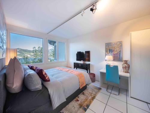 a bedroom with a bed and a desk and a window at Villa Ysara, Pool Villa with lake Lucerne View in Lucerne