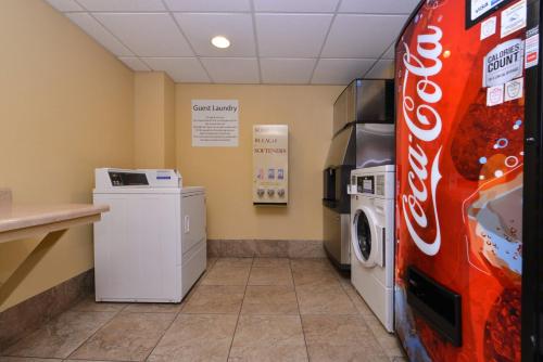 a laundry room with a soda machine and a washer and dryer at Holiday Inn Express Crestwood by IHG in Crestwood
