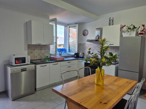 a kitchen with a wooden table and a kitchen with white appliances at Le Mimose Holiday House di Como - Grandate in Grandate