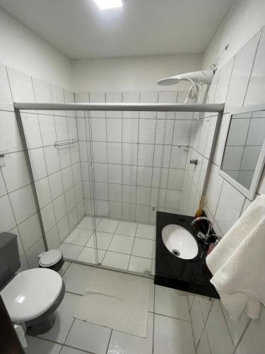 a white bathroom with a sink and a toilet at Pousada - Suíte Excelente in Maceió