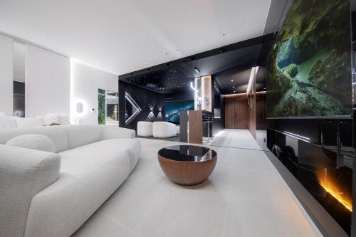 a living room with a white couch and a table at Sky Tower - 48 Piętro Penthousy z Prywatna SPA - ADULT ONLY in Wrocław