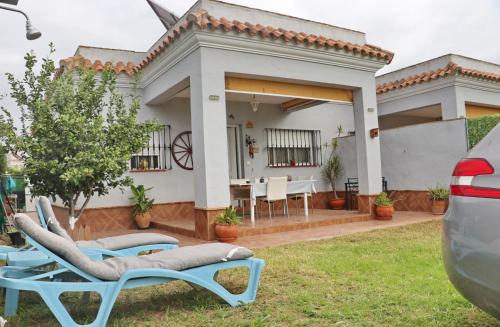 a house with two lounge chairs in the yard at Casa familiar Palmar in El Palmar