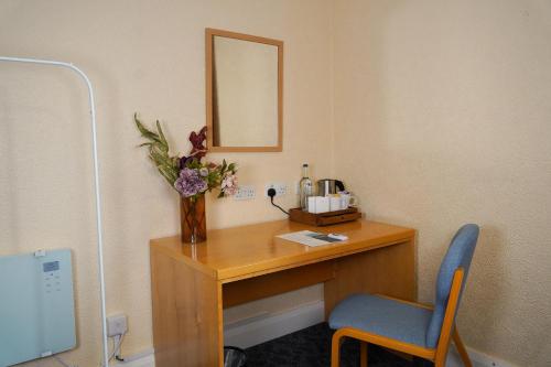 a desk with a vase of flowers and a mirror at Ushaw Historic House, Chapels & Gardens in Durham