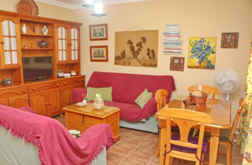 a living room with a red couch and a table at Casa familiar Palmar in El Palmar