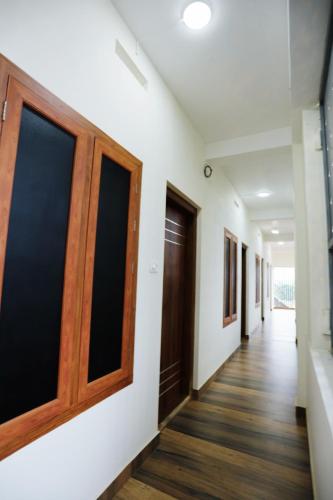 a corridor of an office with doors and wooden floors at Hotel Diamond Castle in Manjeri