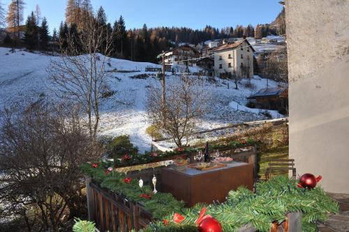 a balcony with christmas trees and a table and snow at Meraviglioso Loft con vista sulle Dolomiti in Colle Santa Lucia