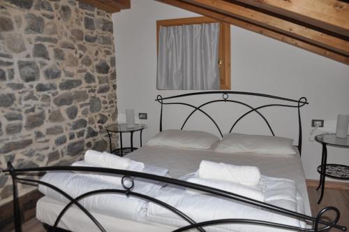 a bed in a room with a stone wall at Meraviglioso Loft con vista sulle Dolomiti in Colle Santa Lucia