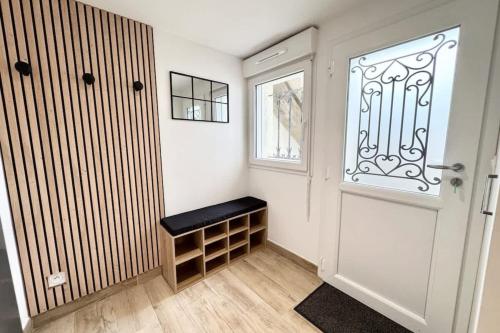 une chambre avec une porte et un banc à côté d'une fenêtre dans l'établissement Lovely ! T2 neuf archi cosy 2, à Quimperlé