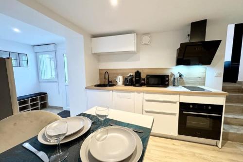 une cuisine avec une table avec des assiettes dessus dans l'établissement Lovely ! T2 neuf archi cosy 2, à Quimperlé