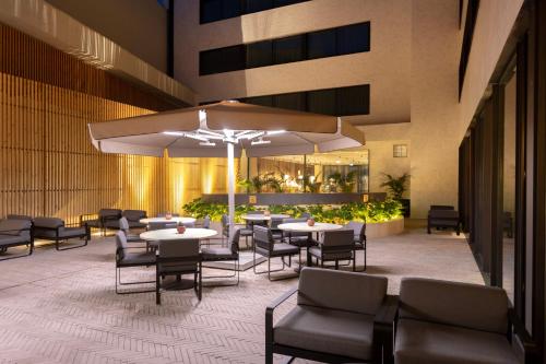 a restaurant with tables and chairs and umbrellas at Altis Porto Hotel in Porto