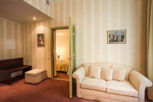 a living room with a couch and a bedroom at Monika Centrum Hotels in Rīga
