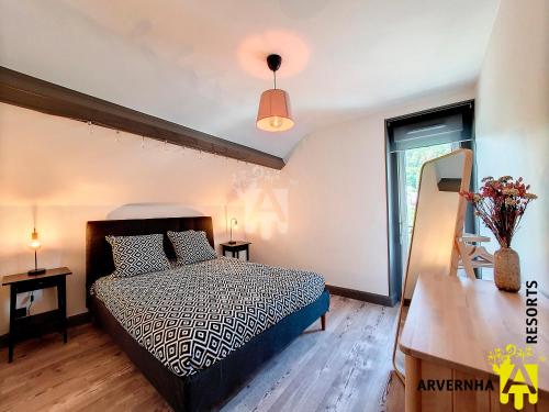 une chambre avec un lit, une table et une fenêtre dans l'établissement La Petite Hirondelle, à Murol