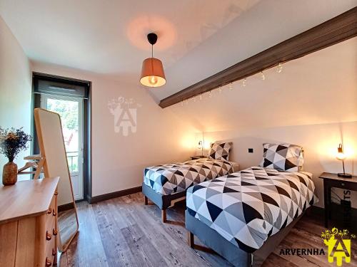 une chambre avec deux lits et une fenêtre dans l'établissement La Petite Hirondelle, à Murol