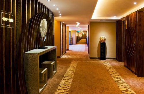 a hallway in a hotel with yellow walls and a long corridor at Hotel Riviera Macau in Macau