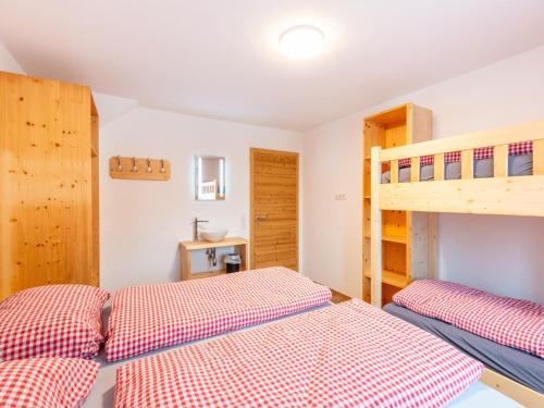a bedroom with two beds and a bunk bed at Farmhouse in Bramberg with Natural Pond in Dorf