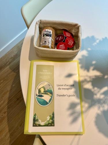 a box of food sitting on a table next to a book at Dans la foret in Châteauneuf-du-Faou